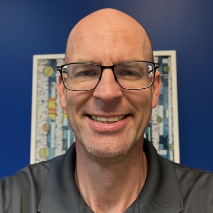 man smiling in front of blue background
