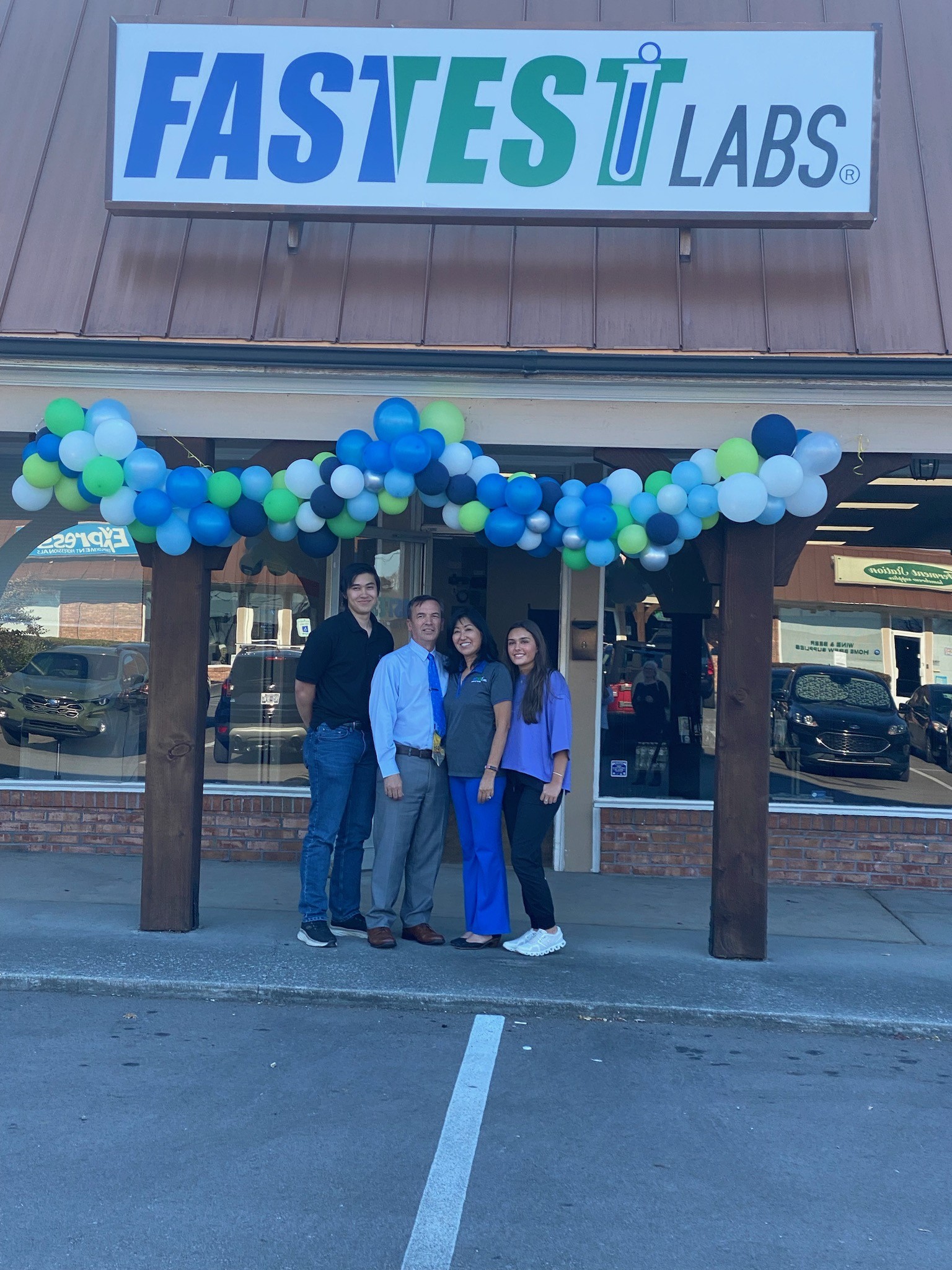 Family grand opening picture in front of signage